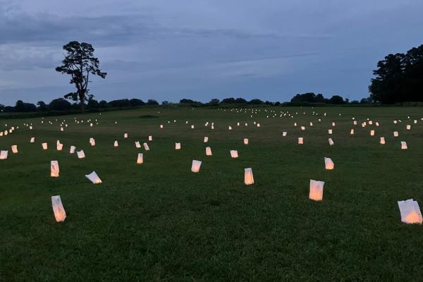 Graves marked by lanterns at Uniontown community remembrance event in Yorktown, VA
