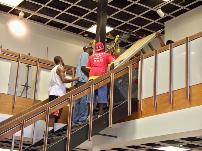 Lee movers carrying the table saw back down to the sculpture studio. Everything from the first floor, including the sculpture equipment, was stored on the second floor during the renovation.