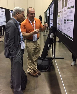 Image 1. Andy Mattei ’19 participates in the ASBMB Undergraduate Research poster competition. Andy (orange shirt) explains his work to a judge.