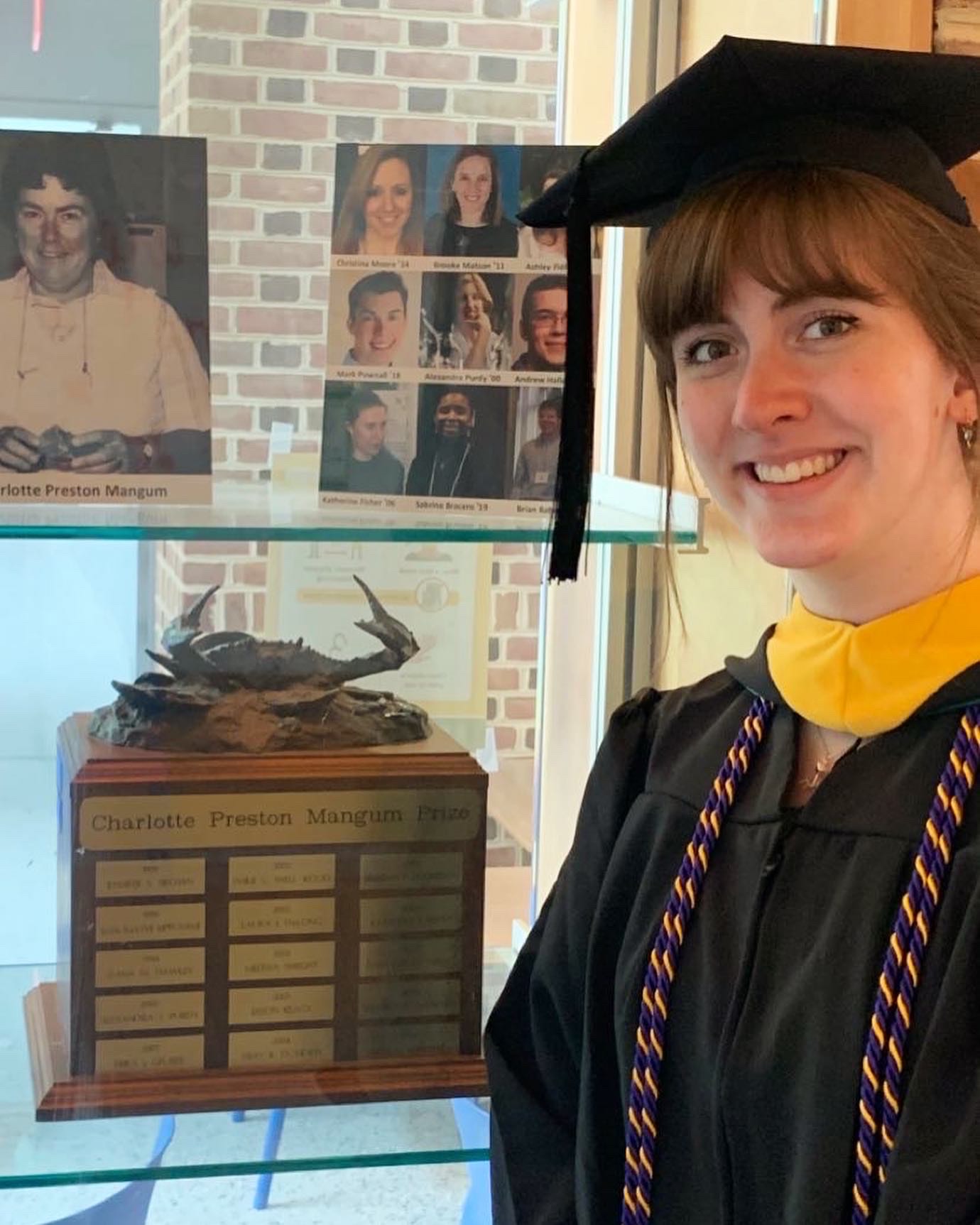 Melaina Jacoby ’21 poses in front of the display case where her name has been added to the list of winners on the Charlotte Preston Mangum Prize