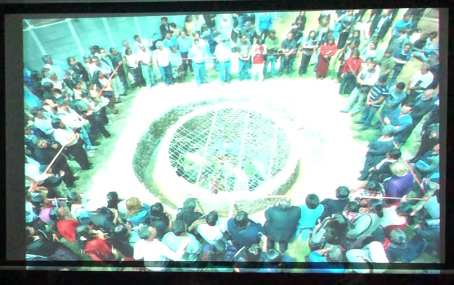Slide 15: A large group is gathered around a circular ossuary.