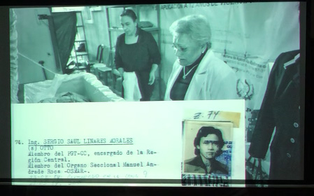 Slide 18: A woman on the right gazes at a skeleton laid out in a morgue. The dossier record is imposed over the main image..
