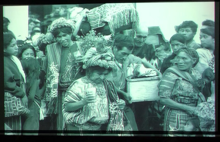 Slide 19: A group of people in Guatemalan dress carry a small coffin