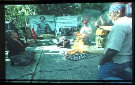 Slide 26: A street scene, with a fire burning in the center. The Angel is in the background. 