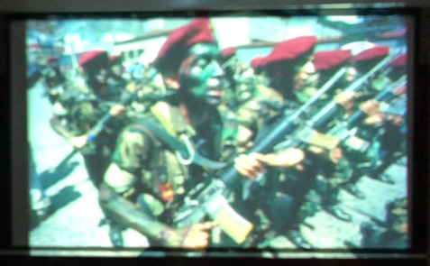 Slide 4: A group of soldiers with painted faces carrying weapons in formation.
