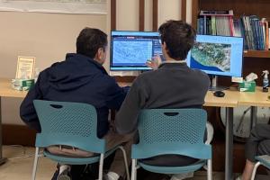 Dr. Palencia-Frener meets with student researcher in the CGA to review maps for the project.