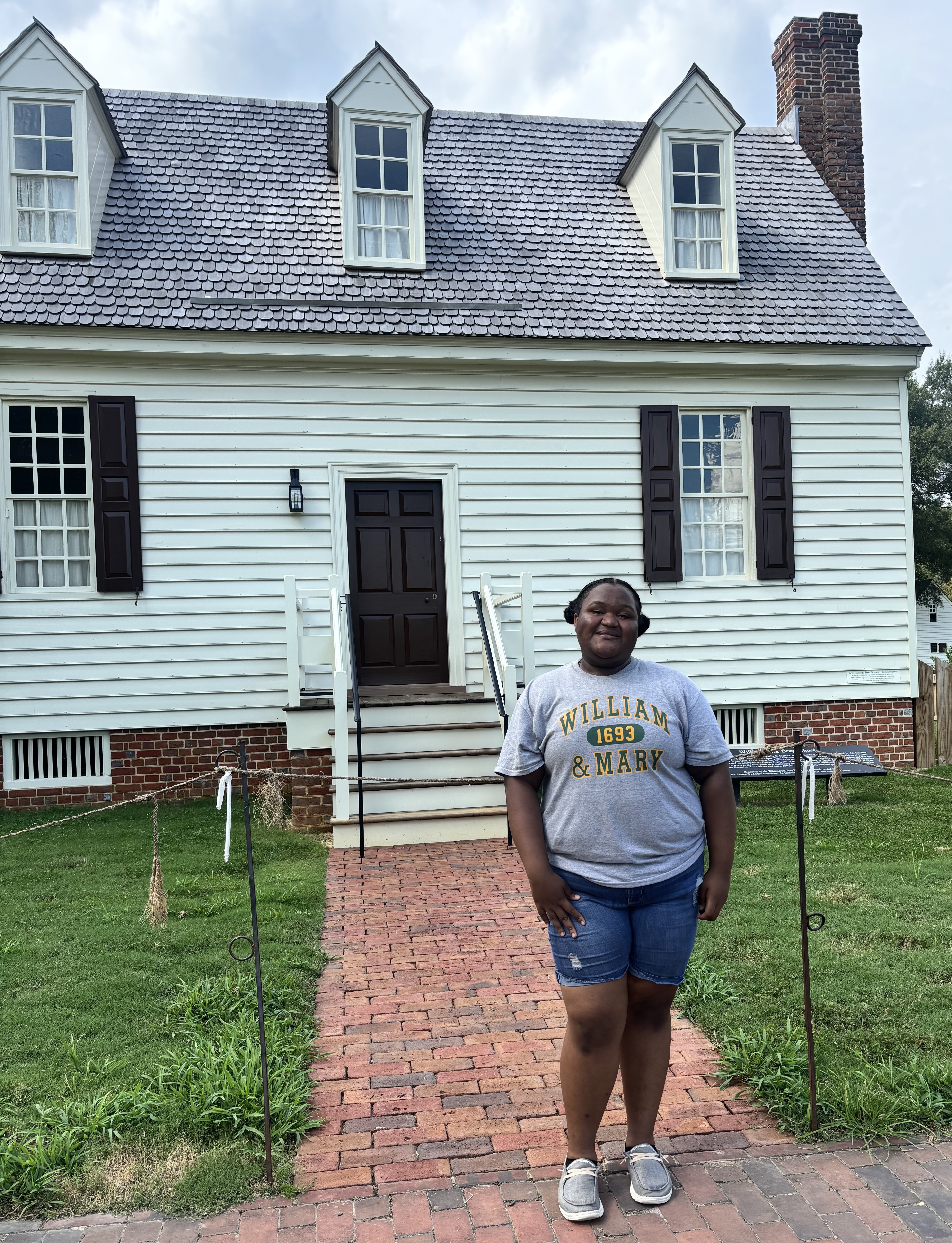 Me'Sharlia Fountain '28 stands in front of the restored Williamsburg Bray School during her Sharpe Action Research internship last summer. (Courtesy photo)