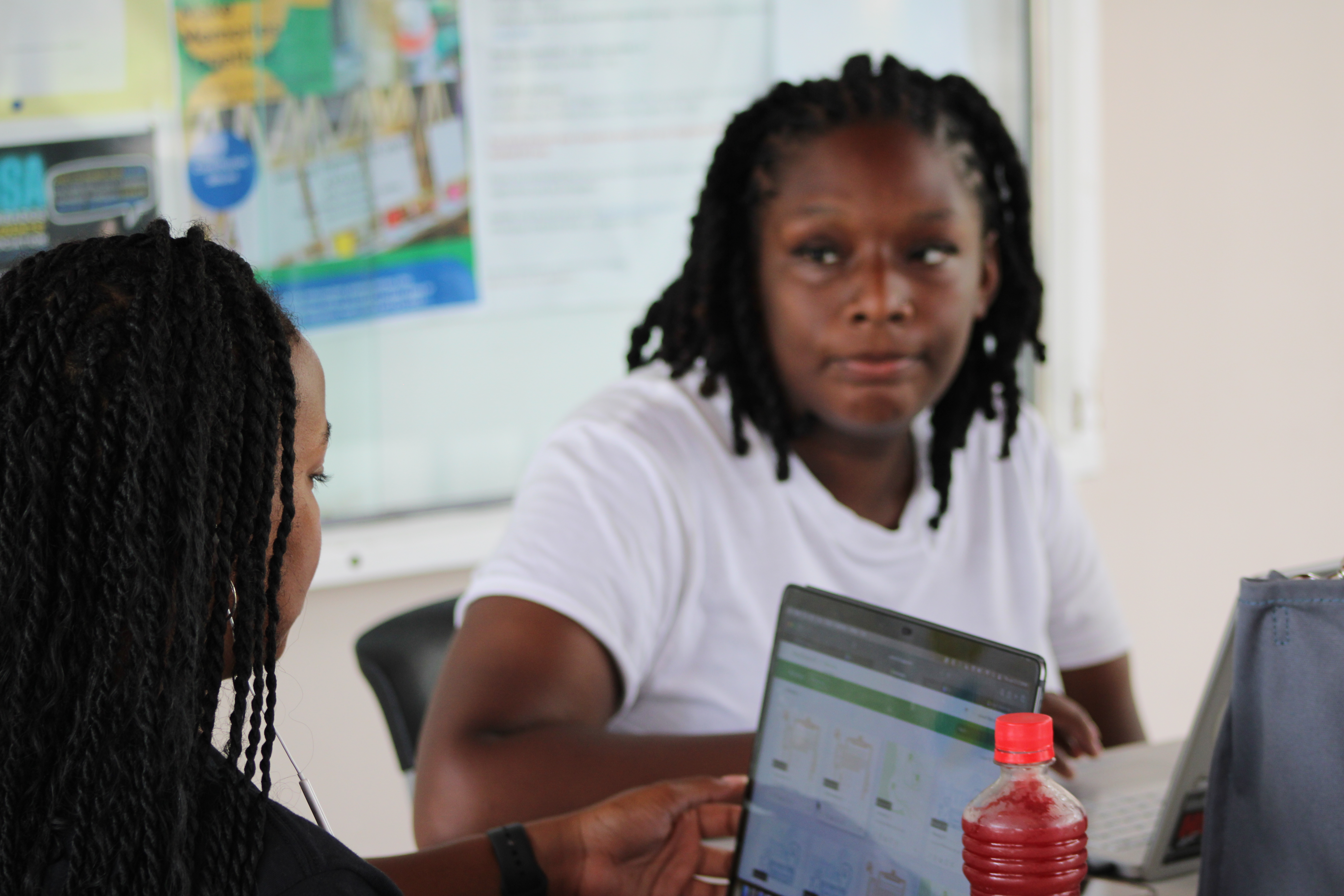 Parah Shaw ‘27 (left) and Naziyah Turner '27 (right) transcribe oral interviews of Barbadian citizens conducted by UWI students. (Photo by Anthony "AJ" Joseph)