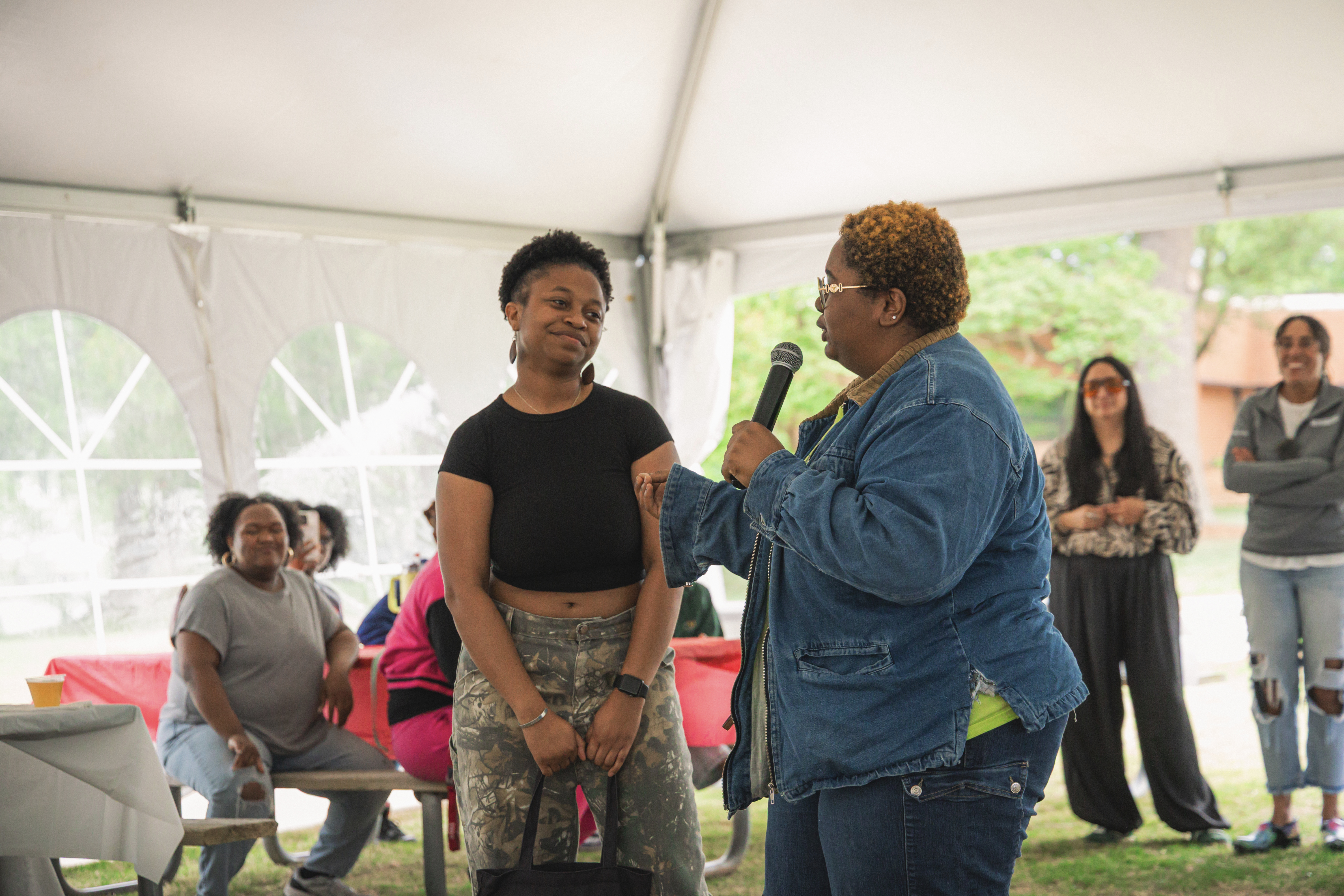 Dativa Eyembe '26 (center, left) receives a warm send-off from Najae Joyner ‘27 (center, right) at WMSURE's end-of-year celebration held at the Virginia Marine Science Institute April 29. (Photo by Samuel Li)