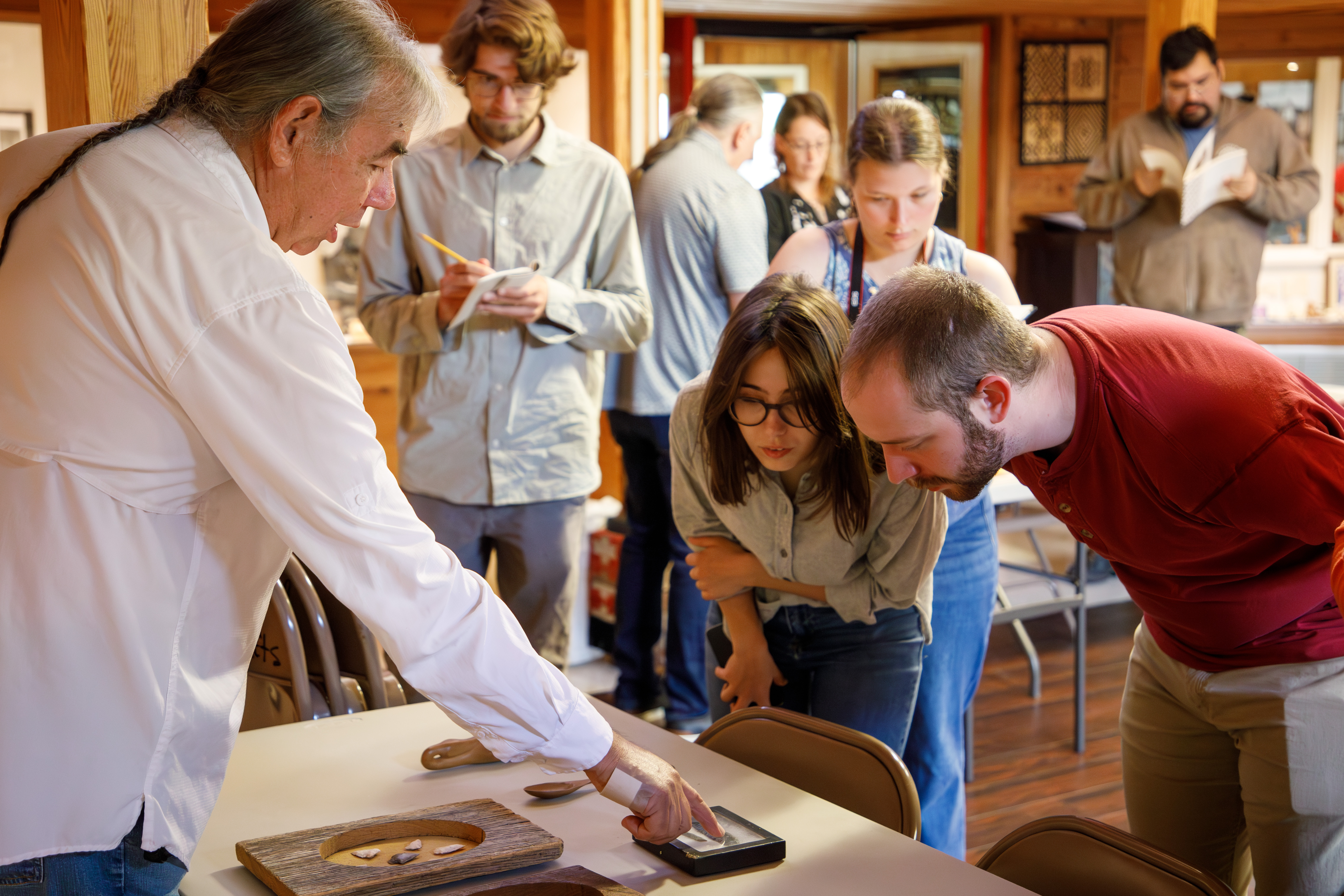 Cherokee traditionalist Davy Arch discusses wood carving and flint knapping with Eliza Fernandez '25 and Jeremy Schwartz '26. In the background, Skyler Smith '26 and Connor DeWall '26 take field notes. (Photo by Grace Helmick)