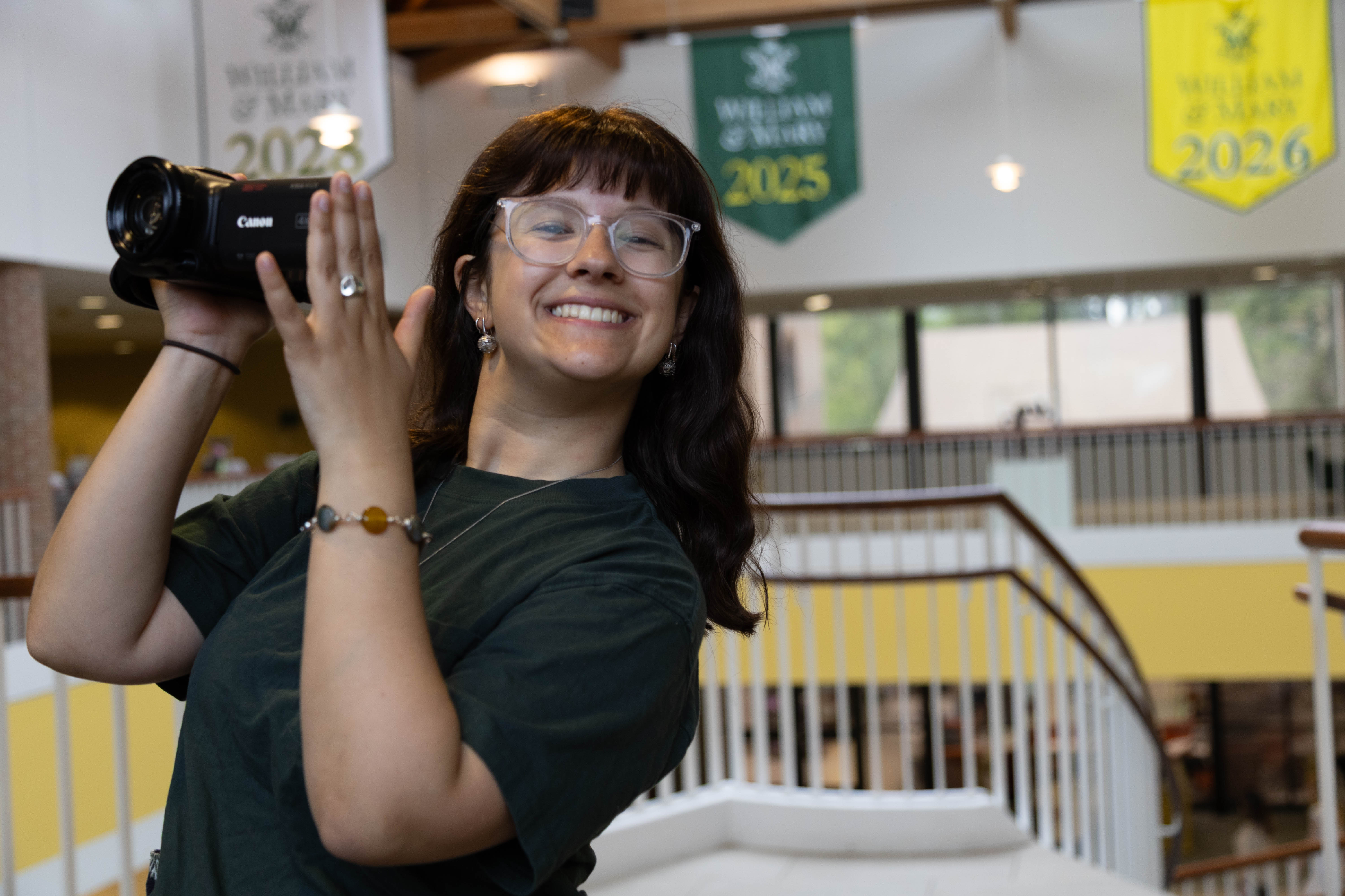 Emma Henry '25, an experienced and versatile journalist, wields a camera while interviewing presenters at the Charles Center's Spring Honors Research Symposium in Sadler Center April 3. (Photo by Tess Willett)