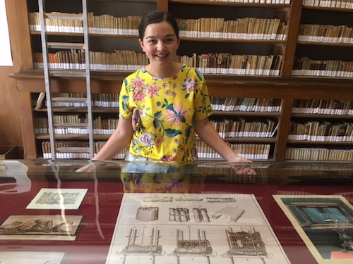 Rachel at the library in Naples in front of a diagram of Piaggio’s papyrus-unrolling machine