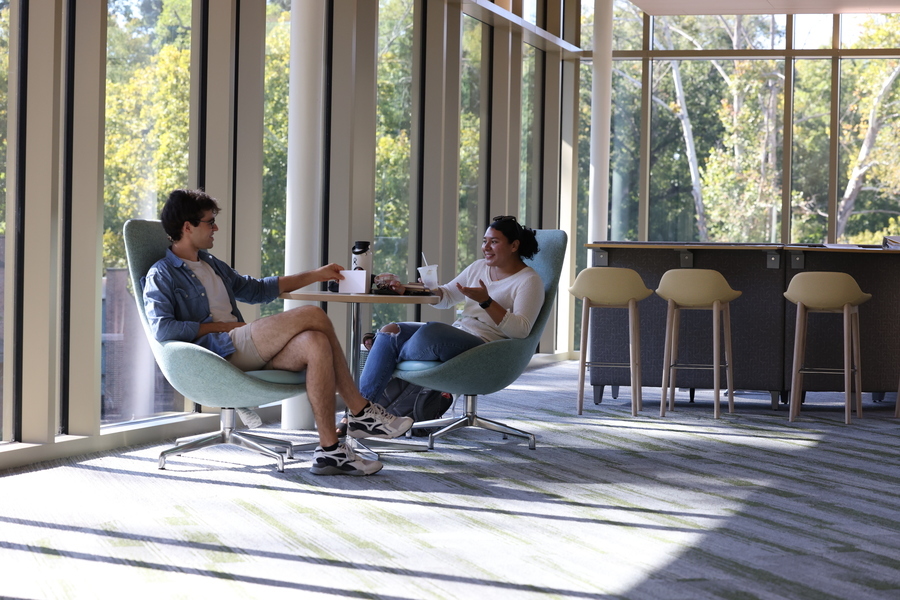 two students sitting in opposite chairs talking