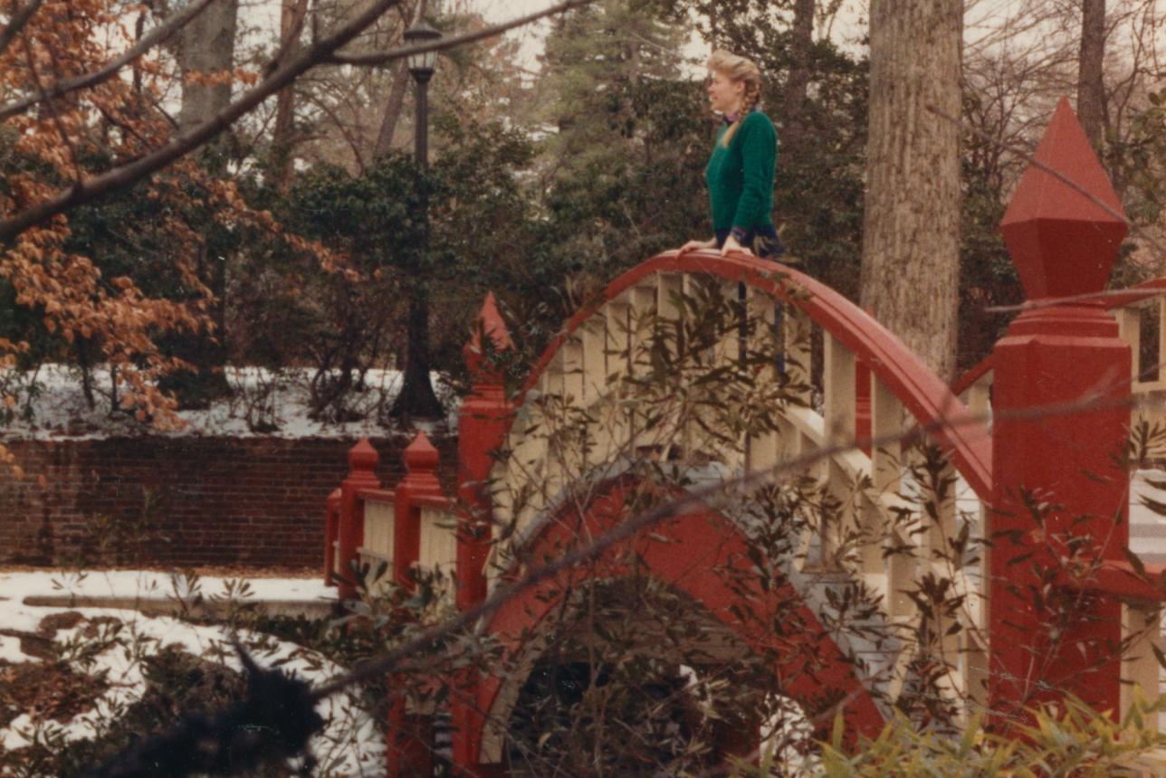 Young woman on William & Mary's Crim Dell Bridge in winter 1987