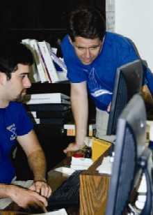 Prof Rob Hicks examines the work done by Brendan Williams '06. Williams, an economics and goverment major, studied abroad in Spain, where he interviewed government officials for PLAID