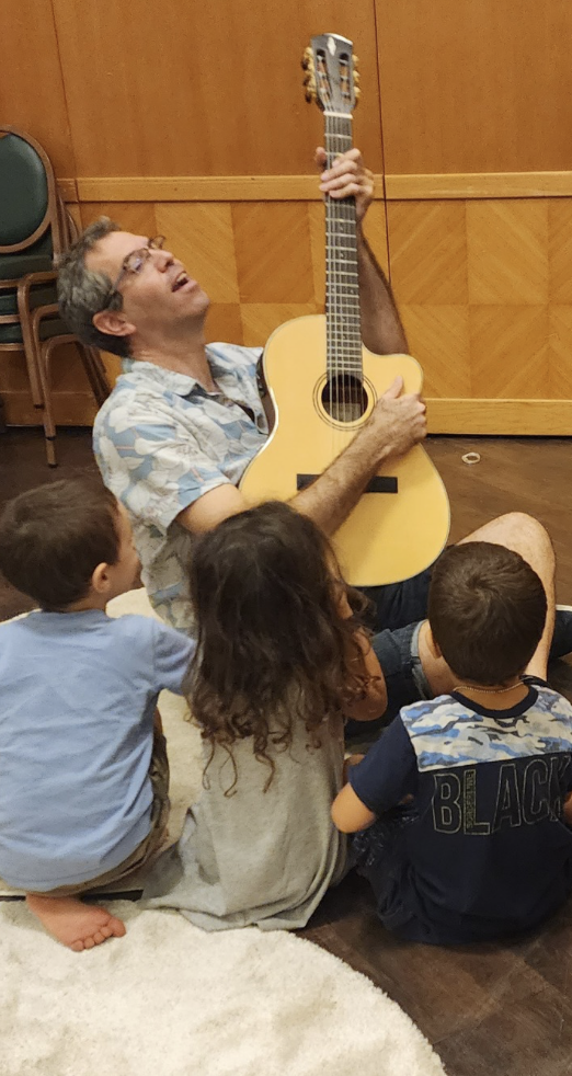 Gilad Perry performing for a group of children.