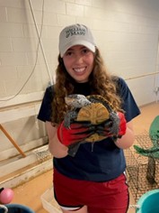 Lindsey holding a diamondback terrapin turtle in a lab