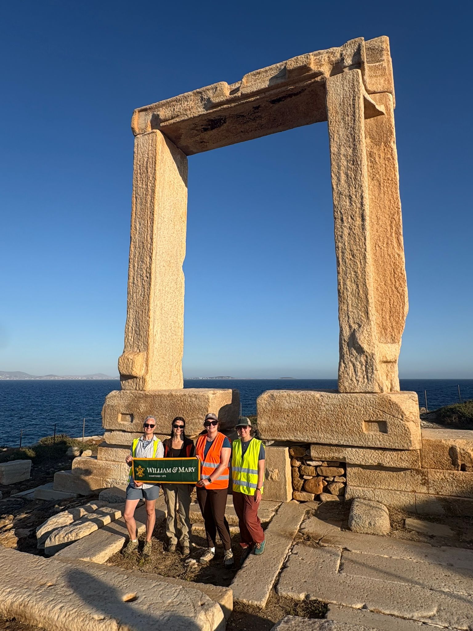 The W&M research team — Jess Paga, Maya Parfitt, Phoebe Kirsh, and Paige Martin — stand in front of the unfinished temple on Palatia, an islet off the coast of the Greek island Naxos. Photo courtesy of Jess Paga.
