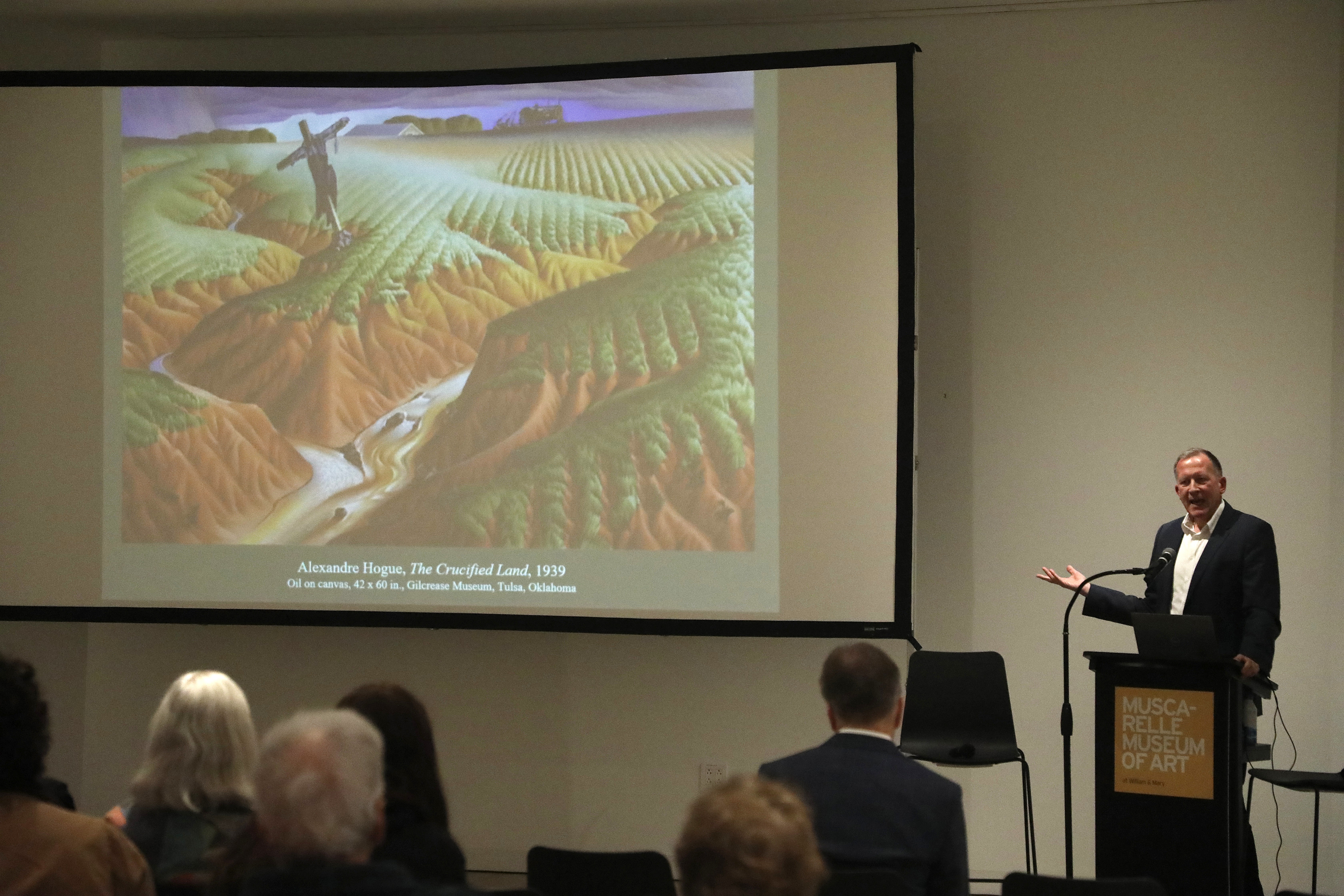 Alan Braddock shows Alexandre Hogue's "The Crucified Land" to the audience at the Muscarelle on Nov. 6.