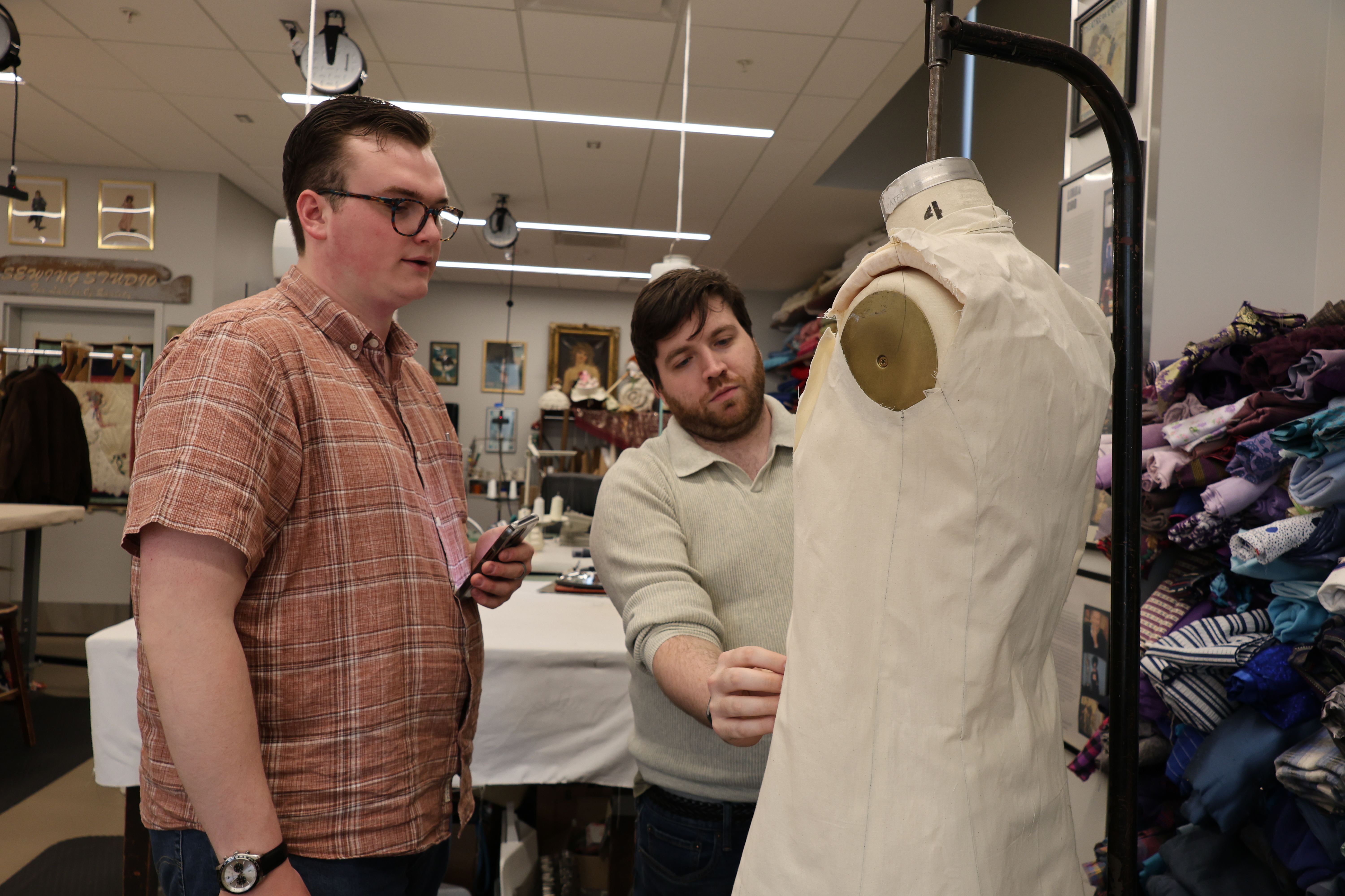 Dominic DiNunzio ‘28 places the muslin mockup of the jacket he constructed for “Machinal” on a mannequin as costume shop manager and mentor Corey Strictland ‘17 provides feedback.