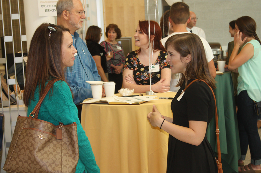 Professor Dallaire, Professor Langholtz, Molly Penrod and Natalie Libster engage in conversation during registration at the Homecoming Open House
