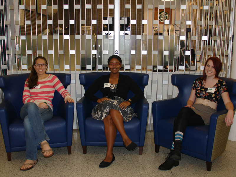 Rachel Scrivano (MA Class of 2019), Lauren Howard (MA Class of 2019) and Molly Penrod (MA Class of 2018) relax in the atrium before the start of the Homecoming Open House