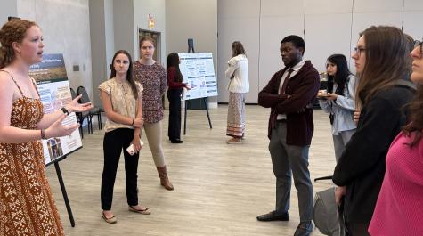 Prof. Nnamdi Osakwe listens as students discuss their poster