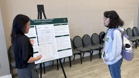 Sophie Yeon discusses her poster with a student 