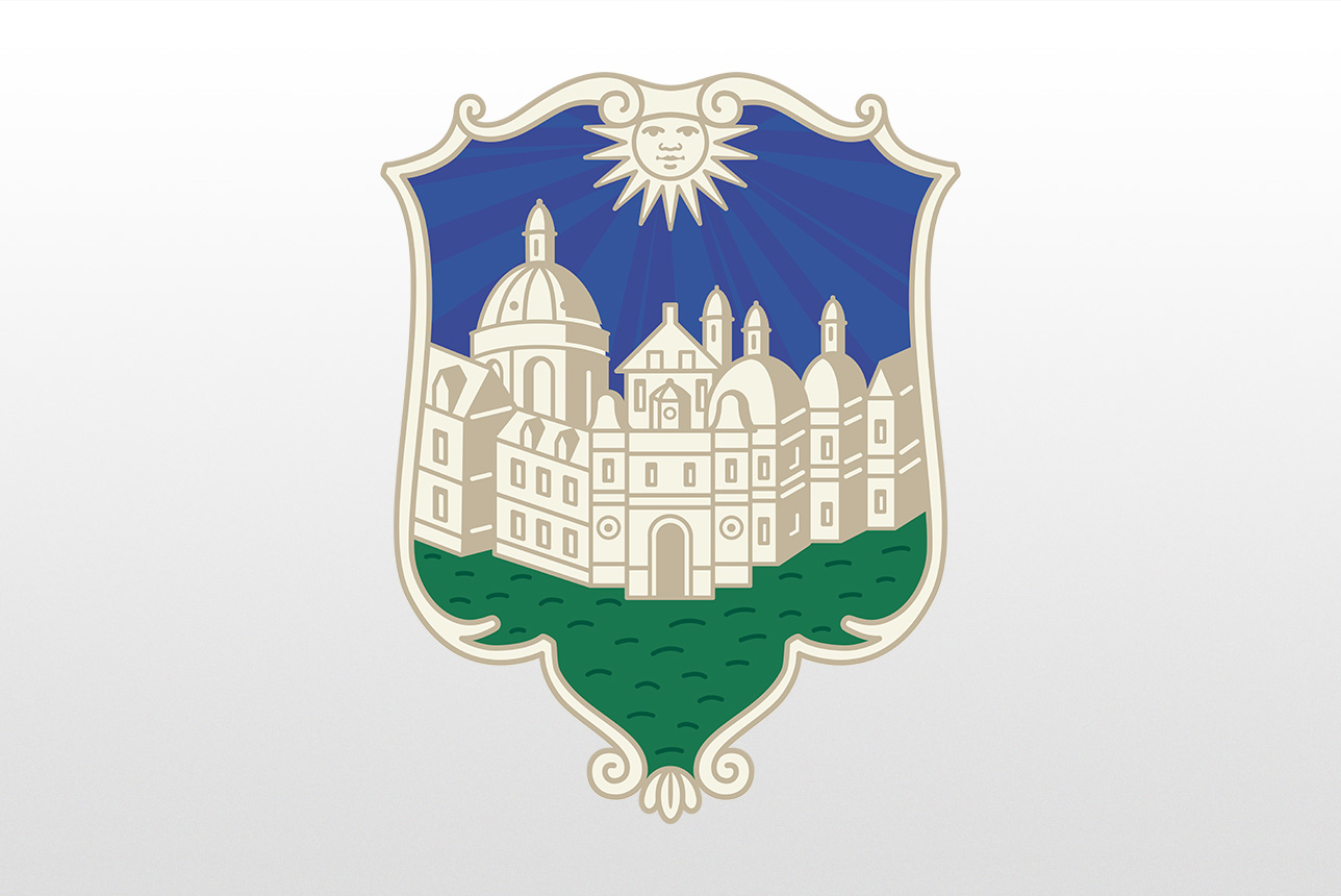 The W&M coat of arms, a shield with a sun at the top, blue sky, building skyline and green grass