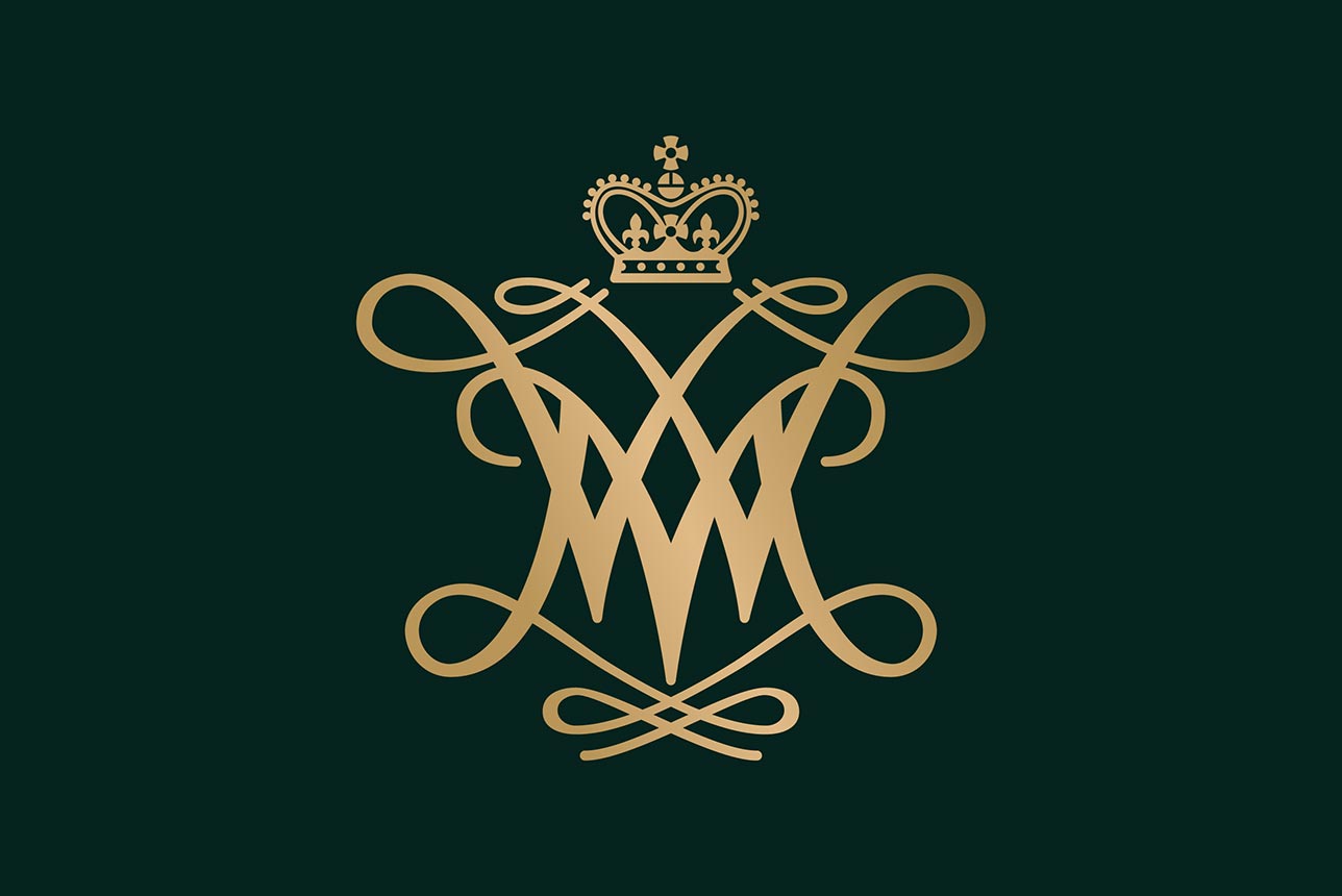 Elegant gold monogram of intertwined 'W' and "M" letters forming a cypher, crowned with a regal crown, on a dark green background