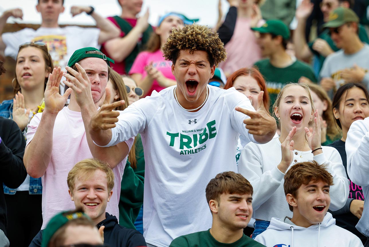 An excited student cheers in the crowd of a football game