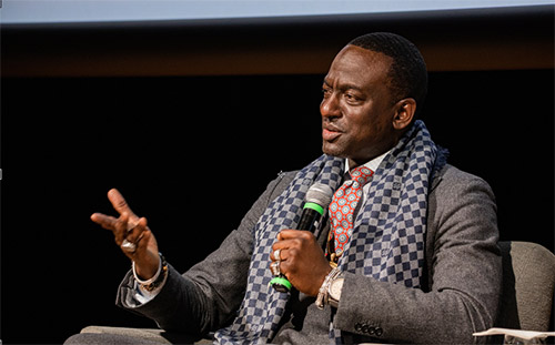 Yusef Salaam sitting on stage speaking into a microphone to the audience at the 2020 Martin Luther King Jr. commemoration