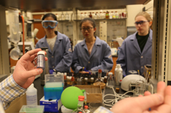 Chemist William McNamara asks lab members (from left) Carolyn Hartley ’15, Dan Liu and Wanji Zhang for their views on the suitability of an abundant-earth catalyst for artificial photosynthesis. | Photo by Stephen Salpukas