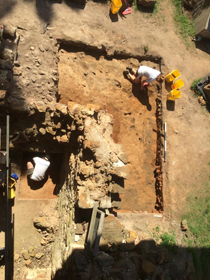 Archaeologists begin cleaning topsoil from a test unit in 2015.