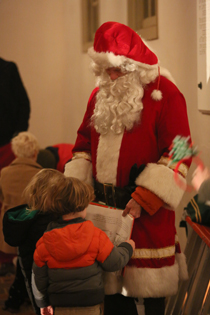 President Taylor Reveley, dressed as Santa, greets some young fans. (Photo by Stephen Salpukas)