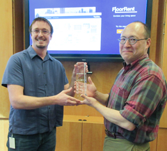 Derek Drummond of Dominion Enterprises (left) presents the HackU Best in Show trophy to Michael Lewis, chair of William & Mary’s Department of Computer Science. The trophy recognizes FloorRent, an app created by a group of William & Mary students. (Photo by Joseph McClain)