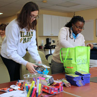 Kim Green '14 (right) and Sarah Walker '20 (left) sort items for the care bags. (Photo by Justin K. Thomas)