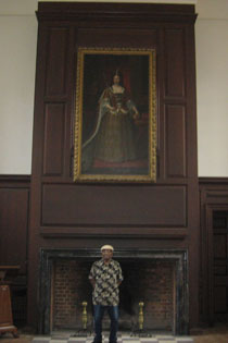 Raymond Bernard Bowman Sr. poses in the Great Hall with his favorite painting in the Wren Building, which is a portrait of Queen Anne by Godfrey Kneller. (Photo by Jennifer L. Williams)