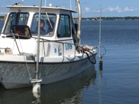 The researchers piloted their instrumented vessel slowly through each oyster farm and its surrounding area, using a bow-mounted acoustic Doppler current profiler to measure current speed and direction, and a stern-mounted datasonde to record chlorophyll, turbidity and dissolved oxygen. (Photo by Grace Massey/VIMS)