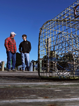 VIMS graduate student Jim DelBene (R) and professional mentor J.C. Hudgins discuss derelict crab pots along a dock on Gwynn's Island. (Photo by Aileen Devlin, Virginia Sea Grant)