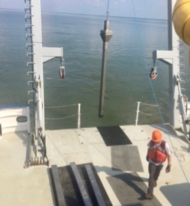 Taylor Moore, mate aboard the R/V Virginia, assists in deployment of a sediment core to test for chlordecone breakdown products in the James River. (Photo by John Olney Jr./VIMS)