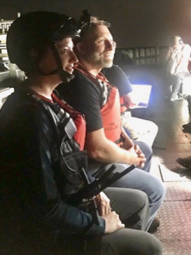 Emily Hein wears a helmet-mounted camera to stream live video back to shore as part of Verizon’s test of night-vision capabilities and other response tools. Also pictured is Brian Province of Maersk. (Photo by Aaron Allen, Maersk Line, Ltd.)