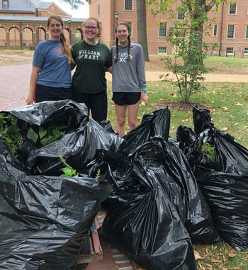 SEAC restoration co-chairs (from left) Danie Barnes ’20 and  Madison Powell ’21 look over some bagged-up stilt grass with geology student Rebecca Topness ’22. Photo by Linda Morse