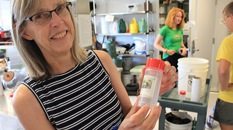 Greenhouse manager Patty White Jackson displays a container for predatory insects. 