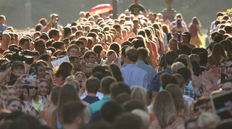 Students walk through a crowd of people lined up to greet them. (Photo by Stephen Salpukas)