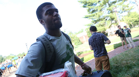 A new student carries belongings to his dorm
