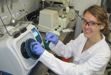 Joanna Weeks operates the bead ruptor in Oliver Kerscher’s lab in 2013. The instrument shakes pickled ticks in a vial of tiny glass beads to break down the tick’s tough exoskeleton.  Photo by Joseph McClain