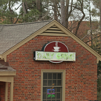 A brick building with a sign saying The Daily Grind