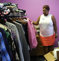 Kimberly Weatherly looks at one of many clothing pieces hanging on a rack