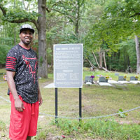 Travis Harris stands in front of gravestones at Oak Grove Cemetery